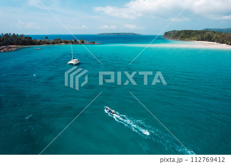 Boat floating on blue water at tropical island 112769412