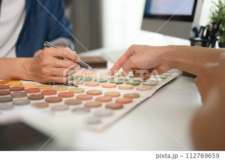 Closeup client choosing colors in swatches palette for apartment renovation 112769659