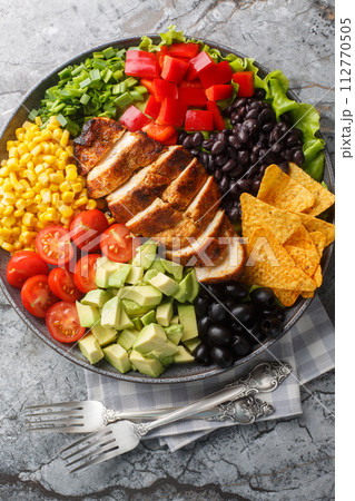 Southwest Salad or Santa Fe Salad is the perfect blend of fresh ingredients like lettuce, tomatoes, corn, black beans and juicy chicken breast closeup. Vertical top view 112770505