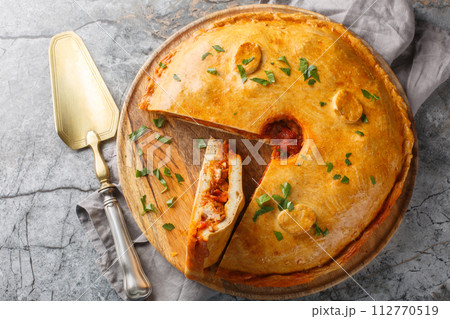 Empanada Gallega Traditional pie stuffed with tuna or meat and vegetables typical from Galicia, Spain closeup on the board. Horizontal top view Empanada Gallega Traditional pie stuffed with tuna or meat and vegetables typical from Galicia, Spain closeup on the board. Horizontal top view 112770519