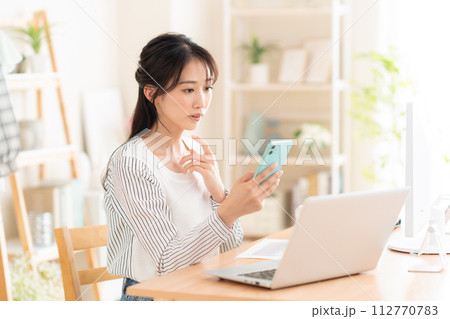テレワークでリビングで働く若い女性 テレワークでリビングで働く若い女性 112770783