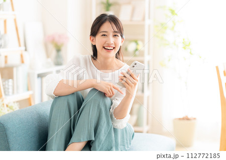 リビングでスマホを見る若い女性 リビングでスマホを見る若い女性 112772185