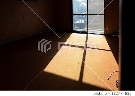 遺品整理をして荷物を運び出して空っぽになった部屋に光が差し込んで影ができているところ 遺品整理をして荷物を運び出して空っぽになった部屋に光が差し込んで影ができているところ 112774683