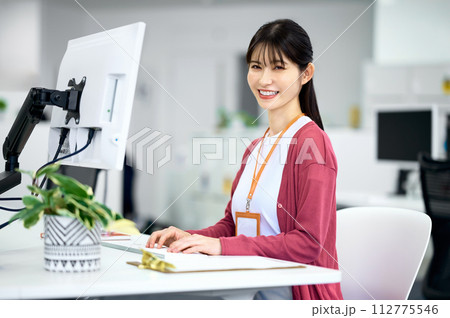 明るいオフィスでデスクワークをする若い女性エンジニア 112775546