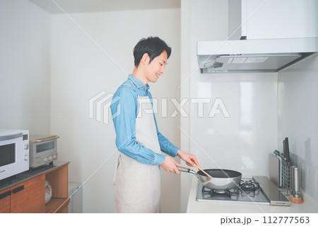 キッチンで料理をする男性 112777563