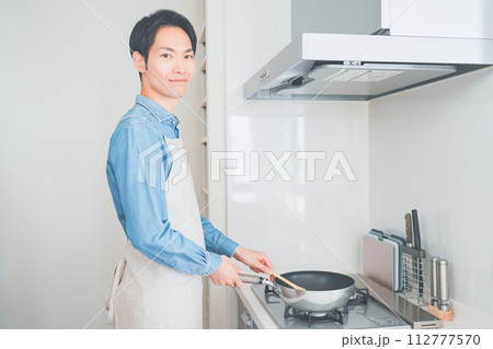 キッチンで料理をする男性 112777570