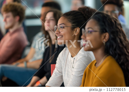 Diverse and engaged audience participating in a multicultural seminar with young adults, professional development, and interactive workshops 112778015