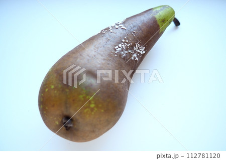 The pear became moldy. A mold or mould. The dust-like, colored appearance of molds is due to the formation of spores containing fungal secondary metabolites. Perishable food products. White background 112781120
