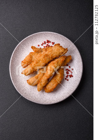 Delicious fresh chicken or turkey strips or nuggets breaded with salt and spices Delicious fresh chicken or turkey strips or nuggets breaded with salt and spices 112782125