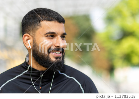 A man pauses his workout to enjoy a moment of rest outdoors, showcasing a lifestyle of health and fitness. 112782318