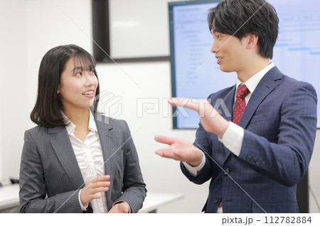 高さを示し話すビジネスマンと少し驚くビジネスウーマン_1 高さを示し話すビジネスマンと少し驚くビジネスウーマン_1 112782884