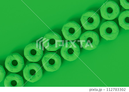 Isometric view of glazed donut with sprinkles on plain monochrome green color Isometric view of glazed donut with sprinkles on plain monochrome green color 112783302