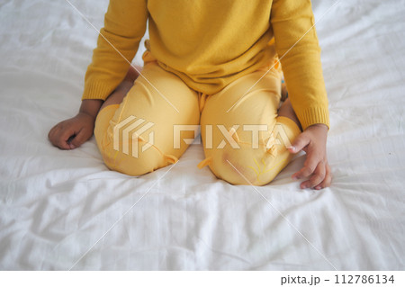 child sitting W posture on the bed  112786134