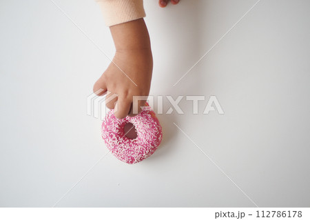top view of child hand pick chocolate donut top view of child hand pick chocolate donut 112786178