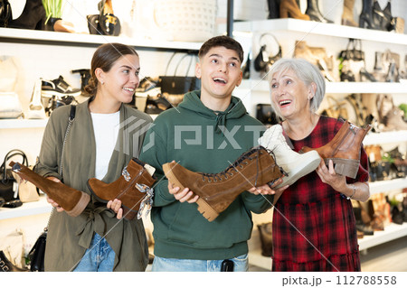 Happy family discussing models of ankle boots in shoe store Happy family discussing models of ankle boots in shoe store 112788558