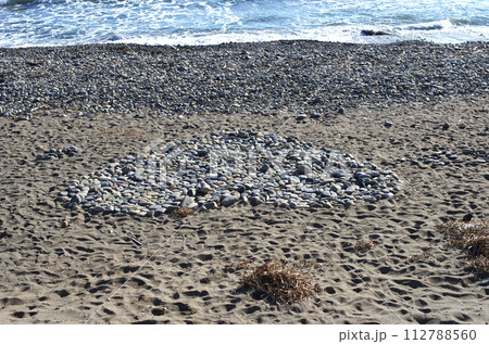 浜辺を歩いていると、大きなハート形の石積みを見つけた。誰か愛する人へのプレゼント？ 112788560