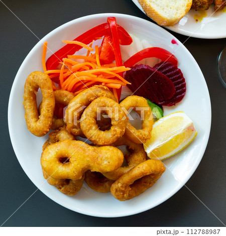 Rings of squid in batter with sliced vegetables.Snack to beer Rings of squid in batter with sliced vegetables.Snack to beer 112788987