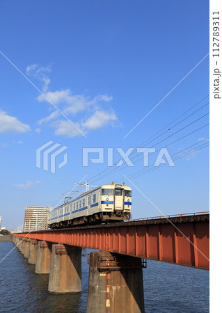 ローカル線・大淀川橋梁と車両形式クモハ717-205と青空 ローカル線・大淀川橋梁と車両形式クモハ717-205と青空 112789311