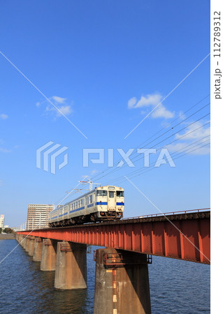 ローカル線・大淀川橋梁と車両形式キハ40系気動車・キハ47 9056と青空 ローカル線・大淀川橋梁と車両形式キハ40系気動車・キハ47 9056と青空 112789312