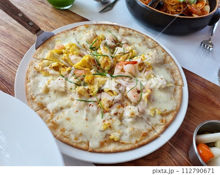 a pizza topped with seafood 112790671