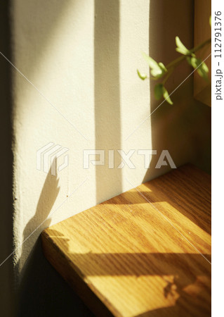 Comfortable rest by the sunny window. A background with sunlight and shadows that can be used in various designs. 112791376