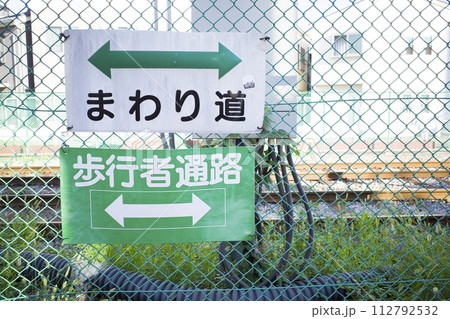 フェンスに貼られた注意の看板 112792532