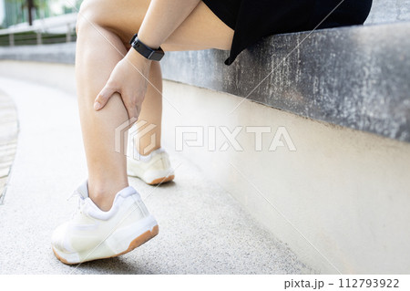 Asian woman have severe cramp her calf of leg,muscle strain,female massaging leg with her hands,suffering from muscular spasms and cramps,contraction of muscles or tendons,physical injury,health care 112793922