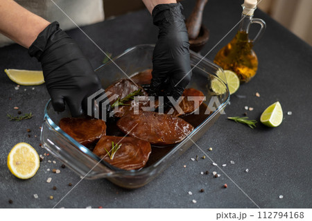 marinated Pieces of Fresh tuna Fish fillet in glass cooking dish on a kitchen table 112794168