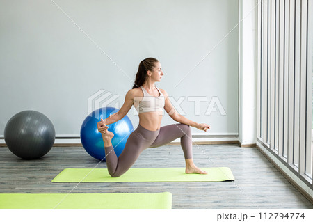 Professional young lady yoga teacher teaches yoga stretching, exercise for health in fitness, the concept of physical and mental health care Professional young lady yoga teacher teaches yoga stretching, exercise for health in fitness, the concept of physical and mental health care 112794774
