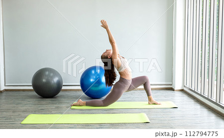 Professional young lady yoga teacher teaches yoga stretching, exercise for health in fitness, the concept of physical and mental health care Professional young lady yoga teacher teaches yoga stretching, exercise for health in fitness, the concept of physical and mental health care 112794775