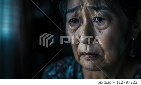 Pensive senior woman gazing through window Pensive senior woman gazing through window 112797222