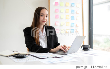 Asian businesswoman calculate financial graphs showing results about their investments, planning a successful business growth process in the office 112798166