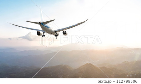 Passengers commercial airplane flying above mountains Passengers commercial airplane flying above mountains 112798306