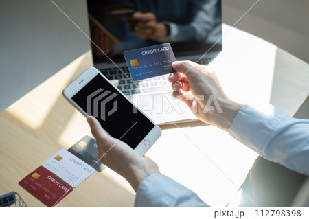 Asian girl shopping online holding credit and using smartphone enter their card number in the mobile phone app to purchase and payment in internet store 112798398