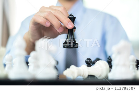 hand of businessmen moving chess in competition shows leadership, followers and business success strategies hand of businessmen moving chess in competition shows leadership, followers and business success strategies 112798507