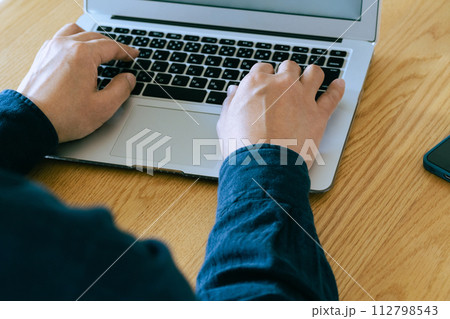 パソコン操作するミドル男性の手元 112798543