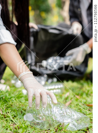 garbage collection, volunteer team pick up plastic bottles, put garbage in black garbage bags to clean up at parks, avoid pollution, be friendly to the environment and ecosystem 112798566