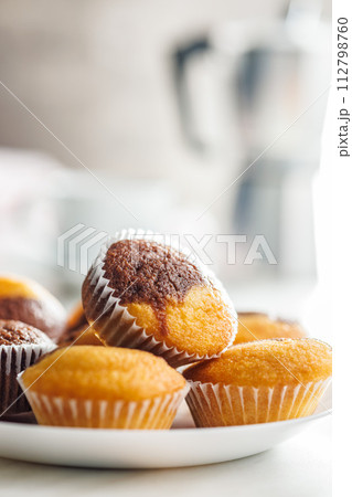 Close Up of a Muffina on plate on a white Table Close Up of a Muffina on plate on a white Table 112798760