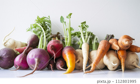 A vibrant array of fresh herbs and vegetables, forms a captivating display on the clear white surface. 112801995