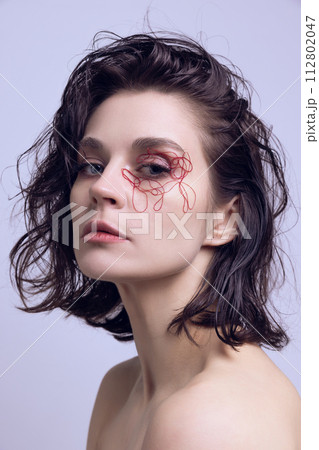 Portrait of beautiful young woman with red tangled strings on eyes and wet messy hair. Face lifting, cosmetological treatment Portrait of beautiful young woman with red tangled strings on eyes and wet messy hair. Face lifting, cosmetological treatment 112802047