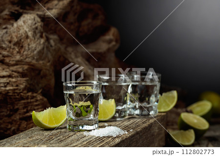 Tequila with salt and lime slices. Tequila with salt and lime slices. 112802773