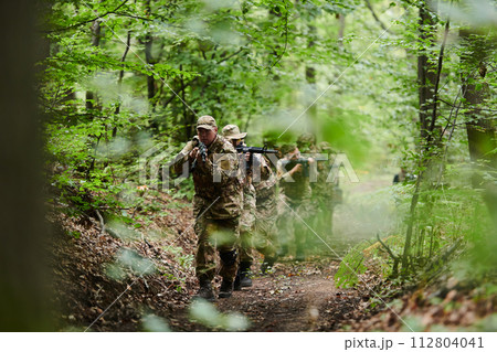 A disciplined and specialized military unit, donned in camouflage, strategically patrolling and maintaining control in a high-stakes environment, showcasing their precision, unity, and readiness for 112804041