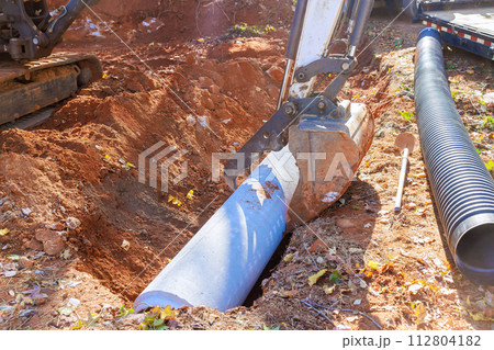 Laying pipes on construction site for flow of rainwater into main collector Laying pipes on construction site for flow of rainwater into main collector 112804182