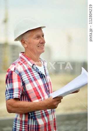 Portrait of an elderly man on a construction site Portrait of an elderly man on a construction site 112804219