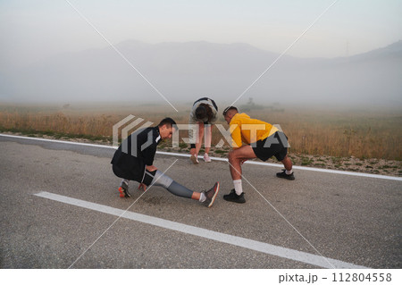 Diverse Athletes Prepare: Dynamic Group Warms Up for Morning Run. Diverse Athletes Prepare: Dynamic Group Warms Up for Morning Run. 112804558