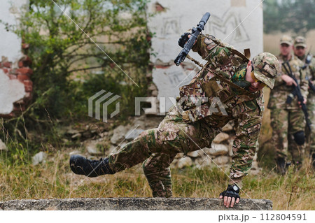 A highly trained elite military unit, clad in camouflage, skillfully navigates through perilous forest terrain, overcoming obstacles and executing a precise and covert mission A highly trained elite military unit, clad in camouflage, skillfully navigates through perilous forest terrain, overcoming obstacles and executing a precise and covert mission 112804591