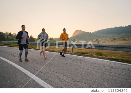 Running towards a common goal, a group of colleagues braves the misty morning air, their determination evident in every stride. 112804845