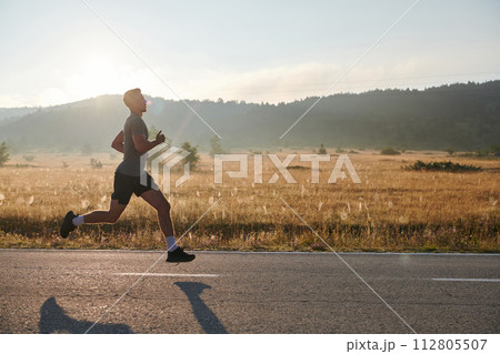 Determined Stride: Athletic Man Embarks on Marathon Preparation with Resolve. Determined Stride: Athletic Man Embarks on Marathon Preparation with Resolve. 112805507