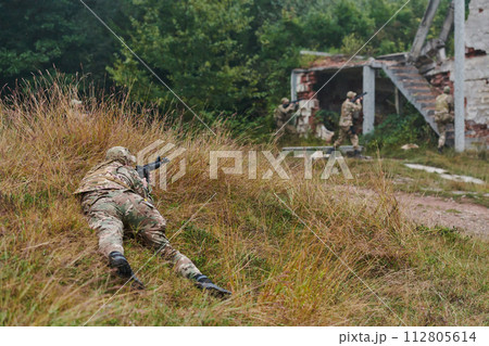 In a high stakes mission, a specialized military unit executes a tactical operation to secure a dangerous house where terrorists are believed to be hiding, showcasing precision and coordinated In a high stakes mission, a specialized military unit executes a tactical operation to secure a dangerous house where terrorists are believed to be hiding, showcasing precision and coordinated 112805614