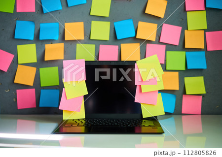 Office workplace with laptop and blank colorful sticky notes reminders Office workplace with laptop and blank colorful sticky notes reminders 112805826